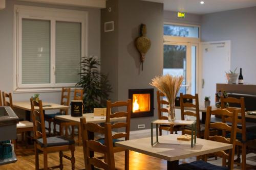 a restaurant with tables and chairs and a fireplace at L Escale in Ports