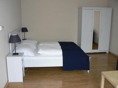 Schlafzimmer mit einem weißen Bett und einem Spiegel in der Unterkunft Apartmán U krále Tylova 516 in Jičín
