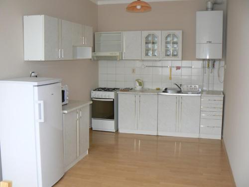 eine Küche mit weißen Schränken und weißen Geräten in der Unterkunft Apartmán U krále Tylova 516 in Jičín