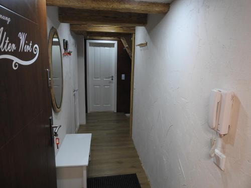 a hallway of a bathroom with a sink and a phone at Alter Wirt in Steckelsdorf