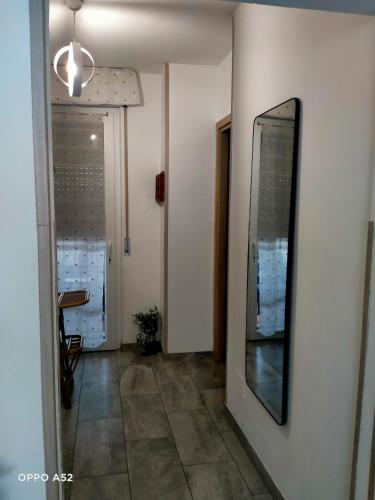 a hallway with a mirror on the wall and a door at Perla di mare in Montesilvano