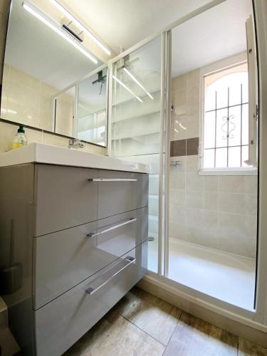 une salle de bain avec douche et lavabo dans l'établissement Jolie petite villa au coeur des Capellans Piscine, à Saint Cyprien Plage