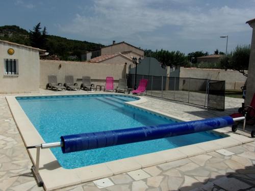 une grande piscine avec un grand tube bleu dans l'établissement En Occitanie - Belle villa familiale avec piscine privée - Idéale avec enfants, à Beaucaire