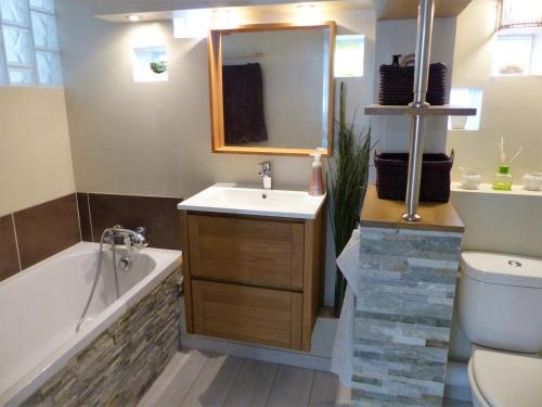 une salle de bain avec une baignoire, un lavabo et des toilettes dans l'établissement Villa en pleine nature prés des plages-Piscine, à Fabrègues