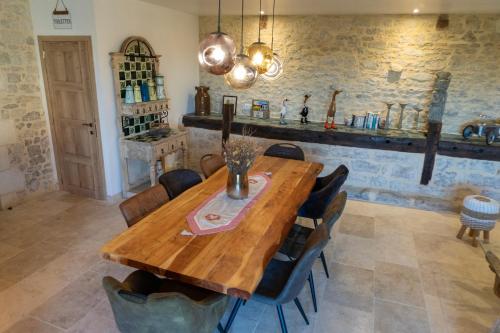 a dining room with a wooden table and chairs at Grange avec vue, proche de Sarlat, calme et dépaysement au coeur du Lot in Beaumat