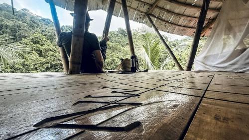 サンタ・マルタにあるBlue Dot - jungle eco hostelの木製の床に座る男