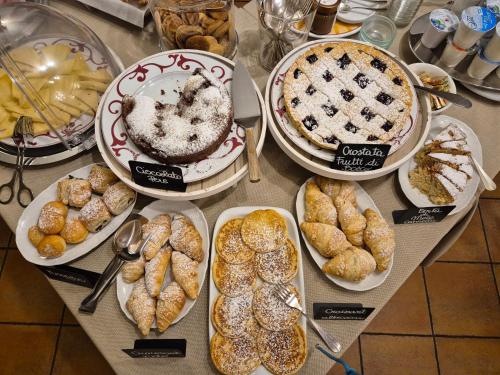 a table with different types of pastries and pies at Hotel Dente Del Gigante in Courmayeur