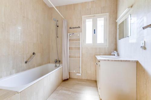 une salle de bain avec une baignoire et un lavabo dans l'établissement Villa provençale face à la mer, à Sainte-Maxime