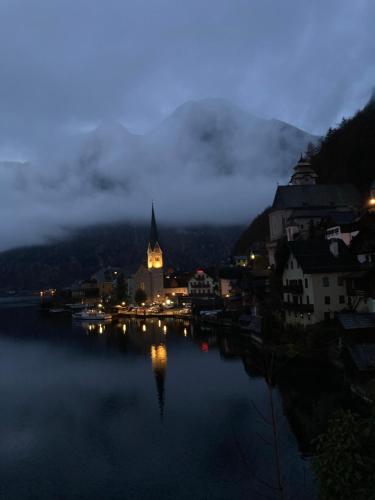 a view of a city at night with the water at Appartementgitti in Hallstatt