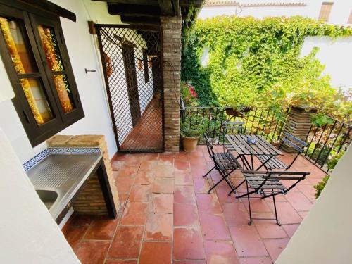 a patio with chairs and a bench and a fence at Posada La Casa Grande in Jimena de la Frontera