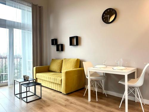 a living room with a yellow couch and a table at Zarembowicza Apt 36 - Self Check-In 20h - Parking &Lift in Wrocław
