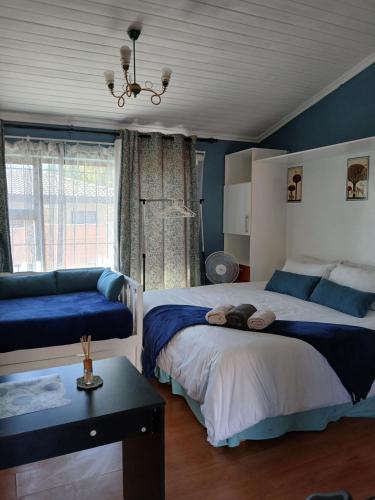 a bedroom with two beds and a chandelier at Stay at Gabby's- no loadshedding in Cape Town