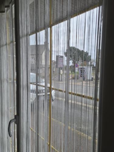 a view of a street from a window with curtains at Appartement T2 spacieux à FREHEL mieux vaut reserver via RBNB in Frehel