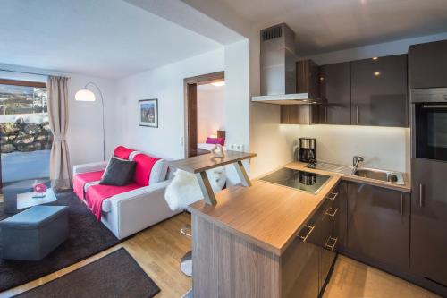eine Küche und ein Wohnzimmer mit einem roten Sofa in der Unterkunft Appartement Klausner in Kitzbühel