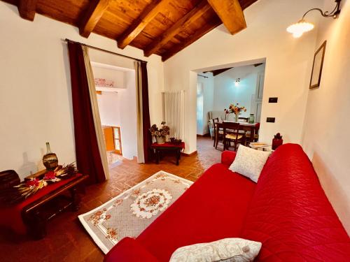 a living room with a red couch and a dining room at Agriturismo Montagna Verde Apella in Licciana Nardi