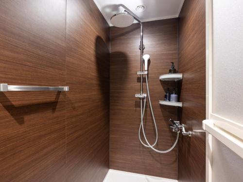 a bathroom with a shower with wooden walls at LACER OKINAWA NAHA Miebashi in Naha