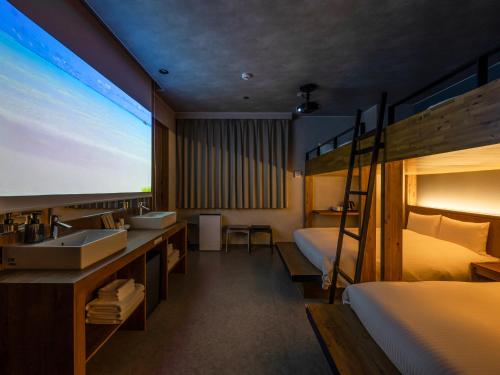 a hotel room with a sink and a bunk bed at LACER OKINAWA NAHA Miebashi in Naha