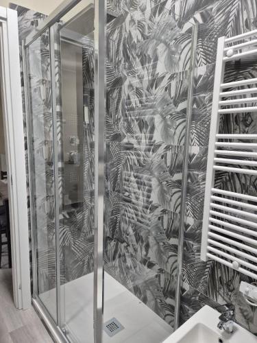 a shower stall with a mural of a plant at Mia Monza Living in Muggiò