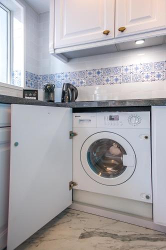 a white washer and dryer in a white kitchen at Hotel Madera Hollywood in Hong Kong