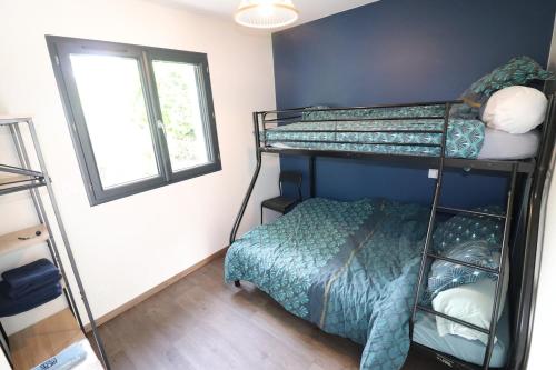 a bedroom with two bunk beds and a window at Gîte cosy aux portes de Sarlat in Carsac-Aillac
