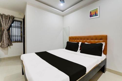 ゴーラクプルにあるSuper Hotel O Aayaanshのベッドルーム(白いベッド、黒い枕付)