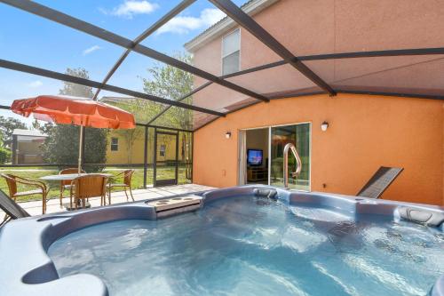 a swimming pool with a table and an umbrella at Three Bedrooms Townhome 3012 in Kissimmee