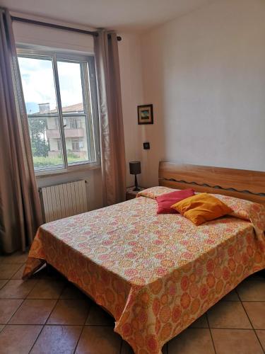 a bedroom with a bed and a window at Appartamento Sabina Rosignano Castiglioncello in Rosignano Solvay