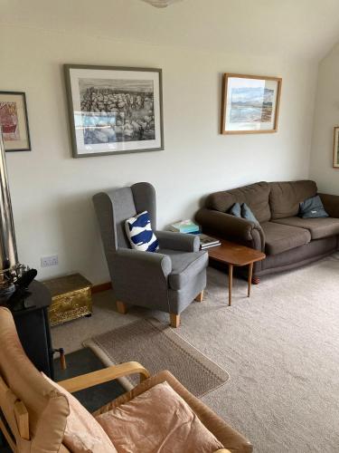 a living room with two couches and a table at Taigh Nandag in Valtos