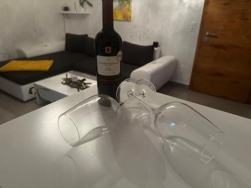 a pair of glasses sitting on a table with a bottle of wine at Ferienwohnung Mölltaler Bergblick in Obervellach