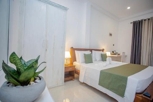 a bedroom with a bed and a potted plant at Monarcho Villa in Talpe