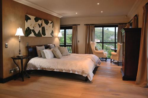 a bedroom with a large bed and two chairs at Villa Seaview in Knysna