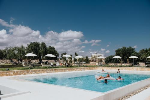 a group of people in the swimming pool at a resort at Masseria Torrepietra in Monopoli