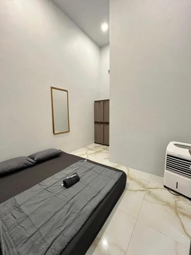 a bedroom with a bed and a air conditioner at Kemari Homestay in Ulin