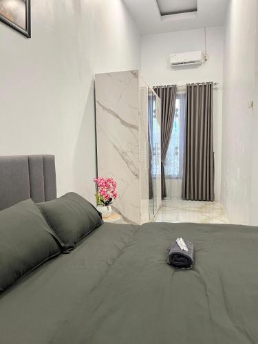 a bedroom with a large bed and a bathroom at Kemari Homestay in Ulin