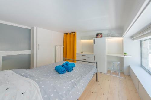 une chambre avec un lit avec des oreillers bleus dessus dans l'établissement MUSICIENS Joli DUPLEX 2 Chambres Garage privatif et Terrasse, à Nice