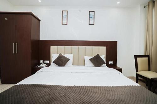 a bedroom with a large bed and a chair at Hotel The 7 Seas in Rishīkesh