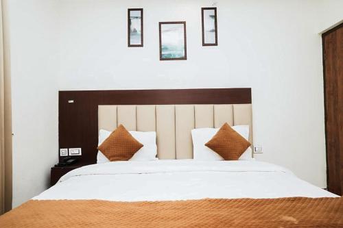 a bedroom with a large white bed with brown pillows at Hotel The 7 Seas in Rishīkesh