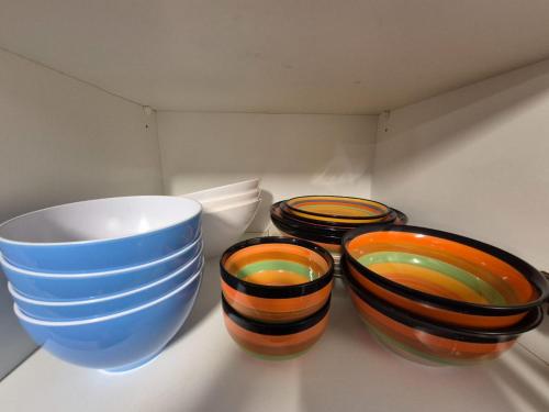 three bowls sitting on a shelf in a cabinet at Spacious cellar studio surrounded by mountains and lake in Schwanden