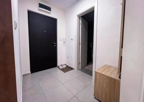 a hallway with two black doors and a tile floor at Apartman Royal 3 in Doboj