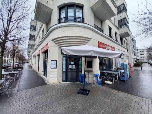 un bâtiment avec un parasol devant lui dans l'établissement Charmant Appartement Disneyland, à Chessy