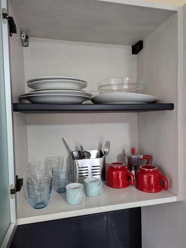 a shelf with plates and bowls and dishes on it at Smart House 19 in Asti