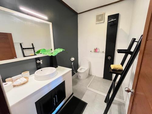 ein Badezimmer mit Waschbecken, Toilette und Spiegel in der Unterkunft Skyline Villa Chalok Baan Kao in Hinkong