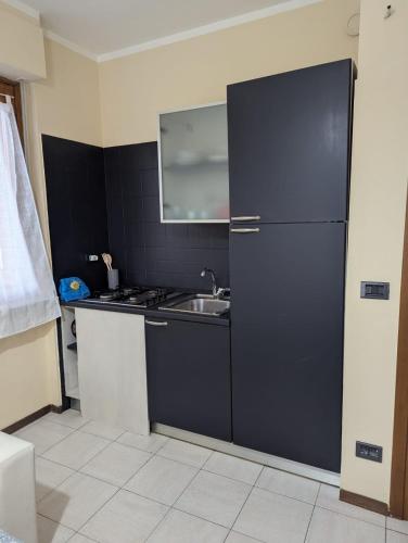 a kitchen with a black refrigerator and a sink at Smart House 19 in Asti