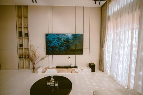 a living room with a tv on a wall at Villa Golf Novaworld in Bình Sum