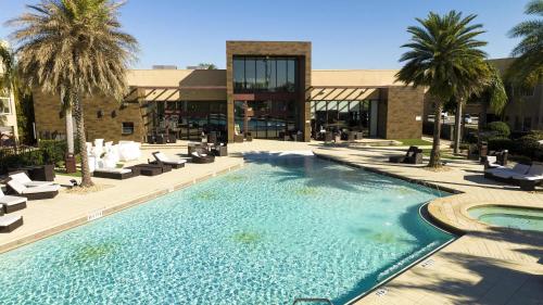 a swimming pool with lounge chairs and a building at Gorgeous 4 Bd Close to Disney @ Magic Village 3114 in Orlando