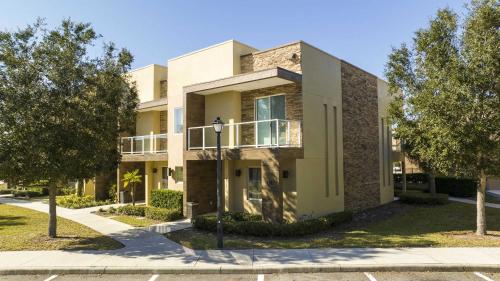 a large building with trees in front of it at Gorgeous 4 Bd Close to Disney @ Magic Village 3114 in Orlando