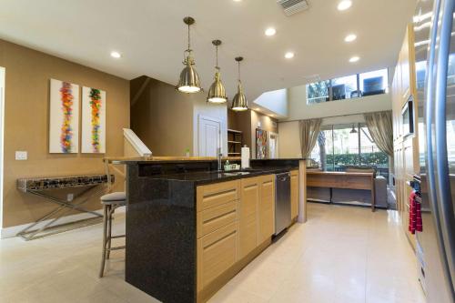 a large kitchen with a black counter top and a table at Gorgeous 4 Bd Close to Disney @ Magic Village 3114 in Orlando