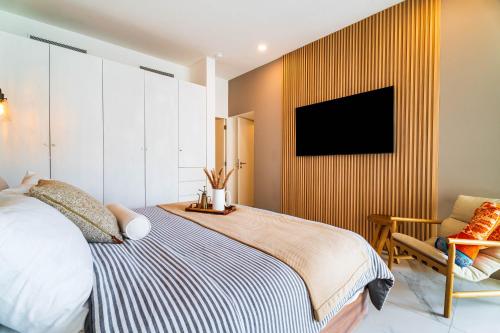 a bedroom with a bed and a tv on a wall at Casa Flor Cabo Your Private Oasis in Cabo San Lucas