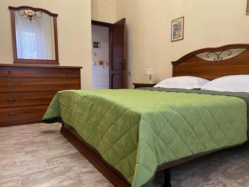 a bedroom with a large bed with a green comforter at Giardino degli Gnomi in Francavilla al Mare