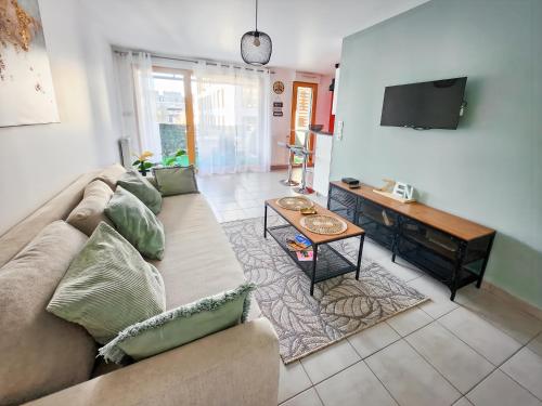 un salon avec un canapé et une table dans l'établissement Studio, Terrasse, Confort & Emplacement Idéal !, à Montévrain